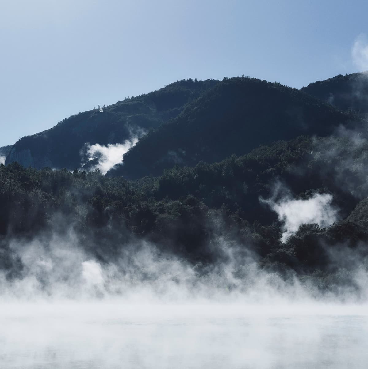 Steam rising in front of a mountain