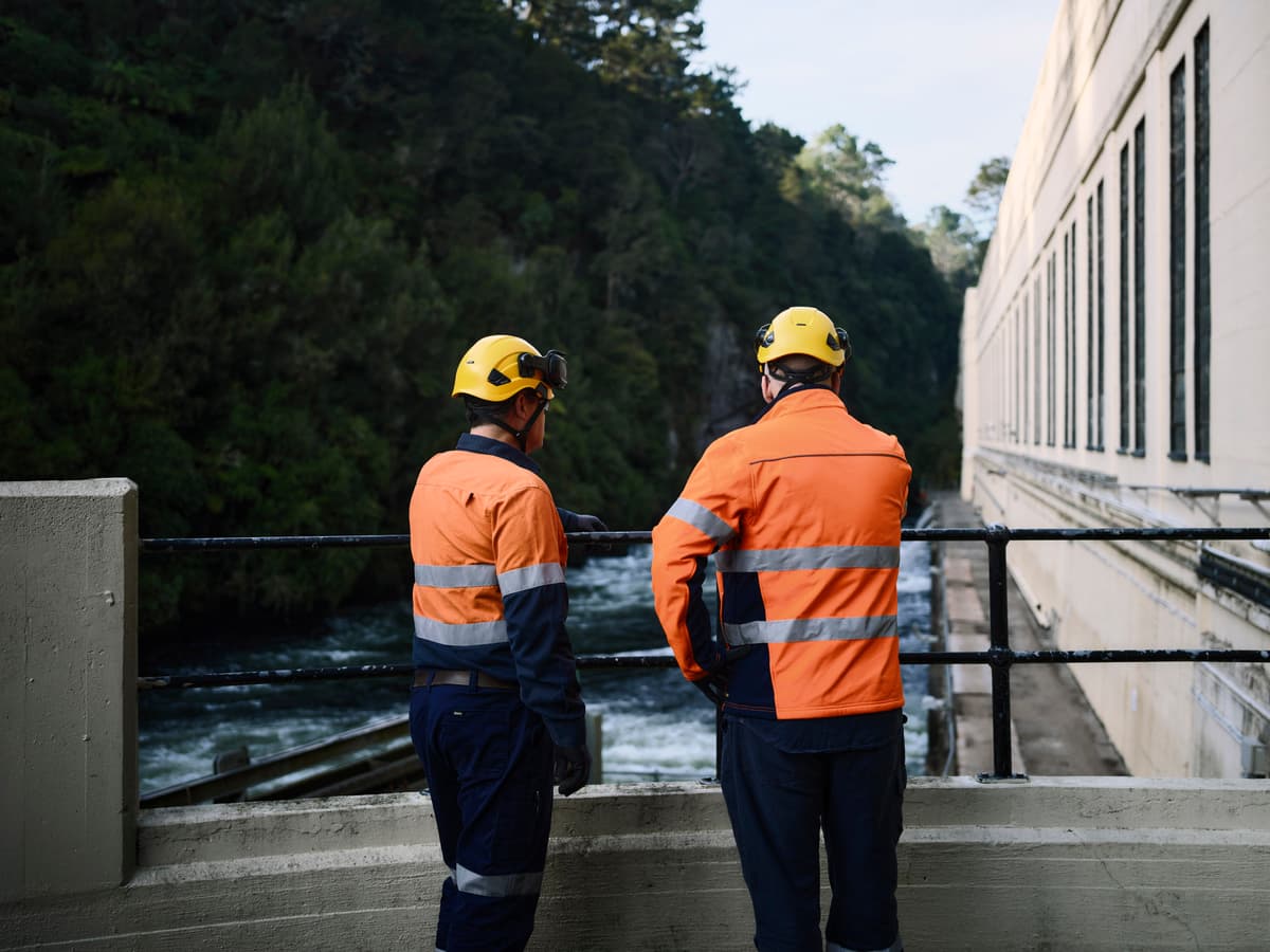 2 workers standing on a dam